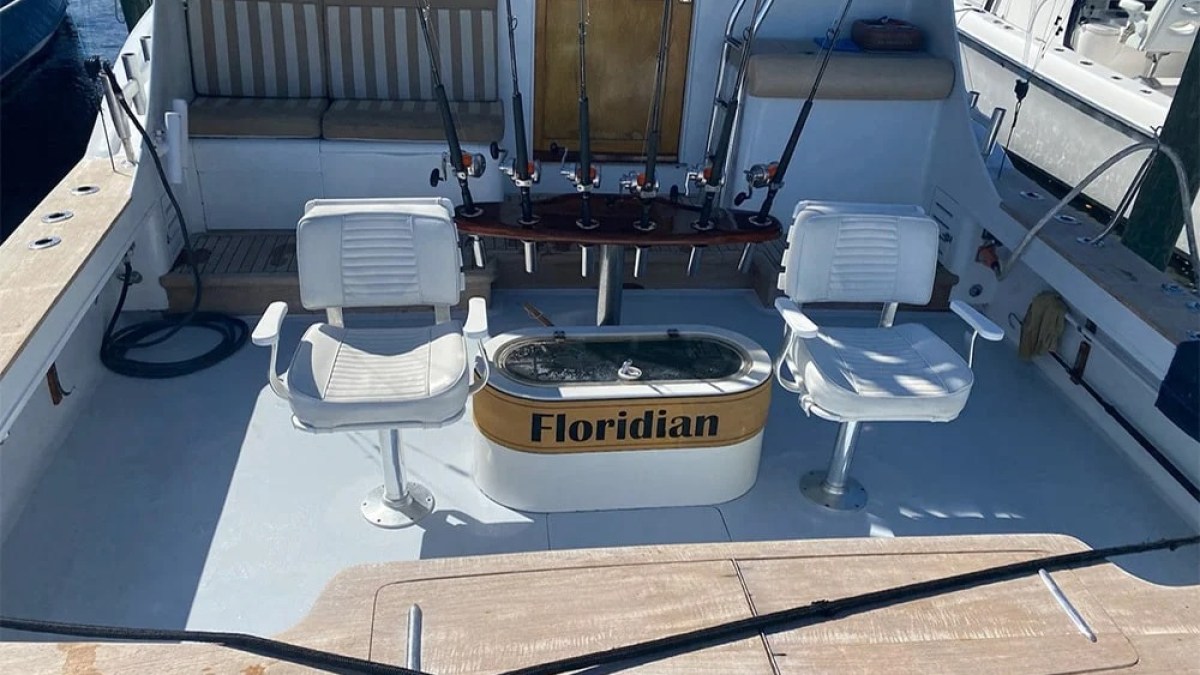 Fishing boat deck with rods, chairs, livewell, and 'Floridian' label.